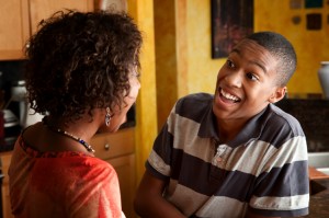 African-American woman and teen laugh in kitchen